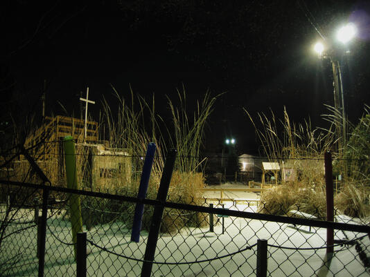 "Cross behind the barb wire fence"